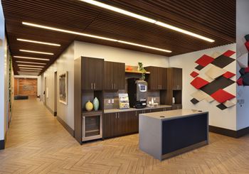 Community kitchenette with dark wood cabinetry